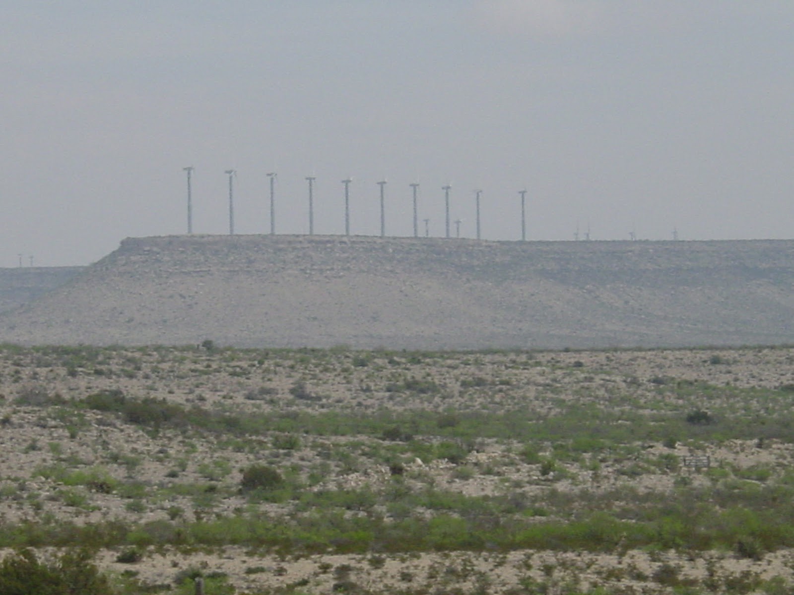 Row of windmills on a distant mesa.