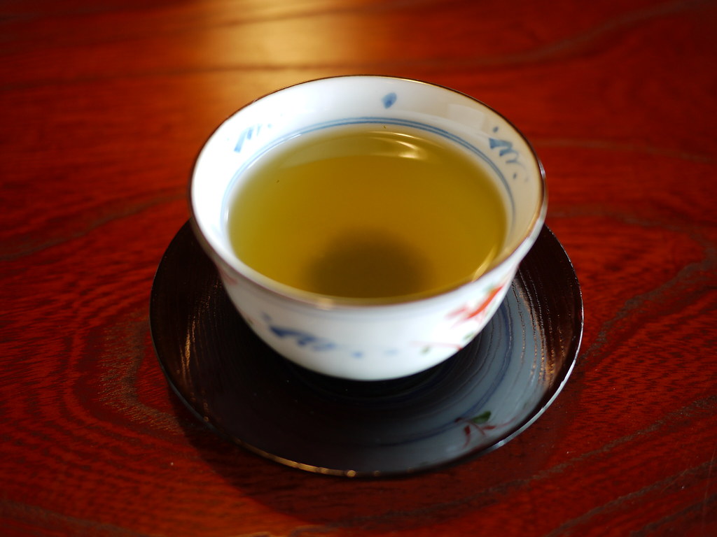 茶碗に入った緑茶の画像　茶たくがついている