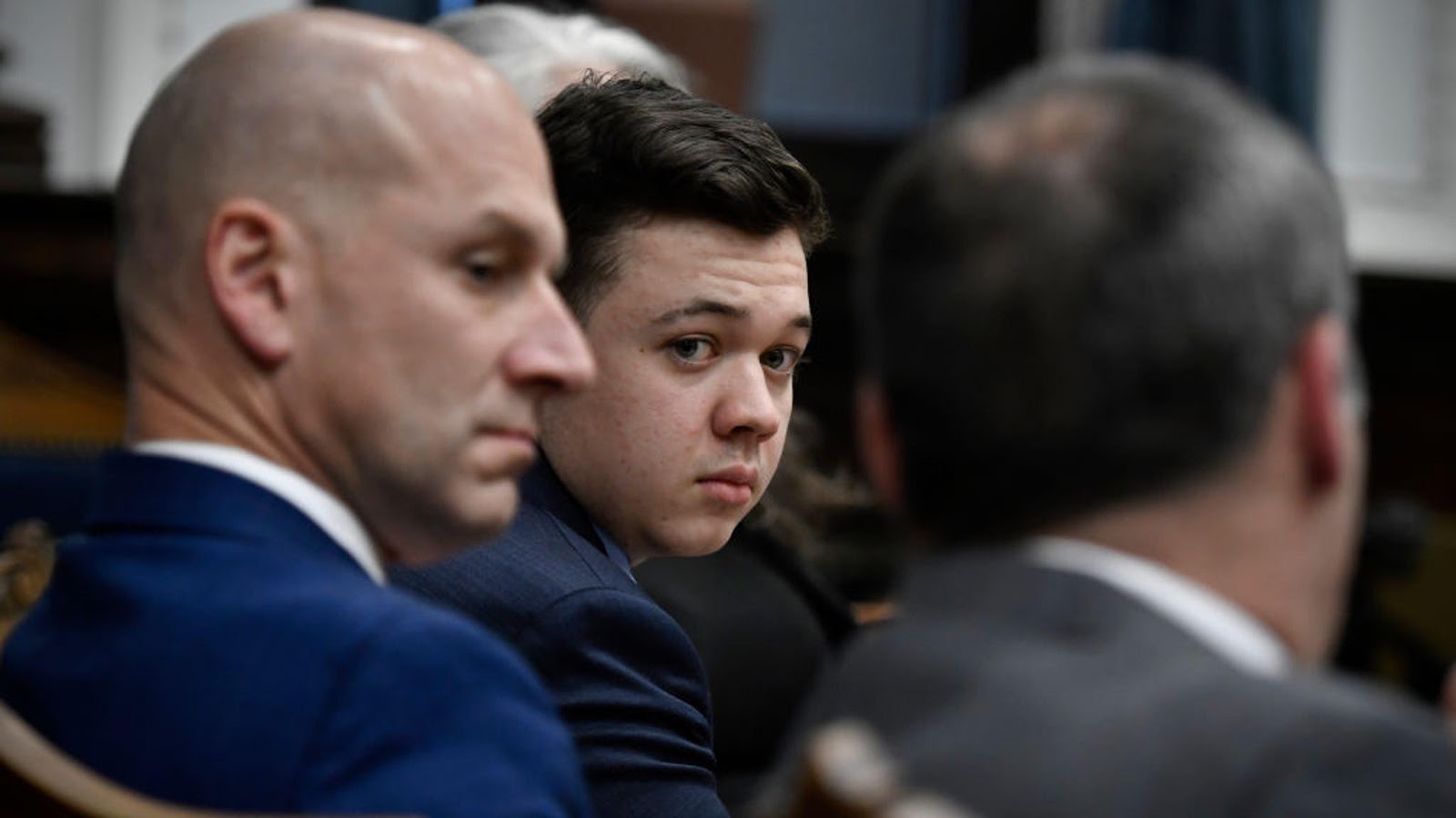 Kyle Rittenhouse, center, looks over to his attorneys as the jury is dismissed for the day during his trial at the Kenosha County Courthouse on November 18, 2021 in Kenosha, Wisconsin.