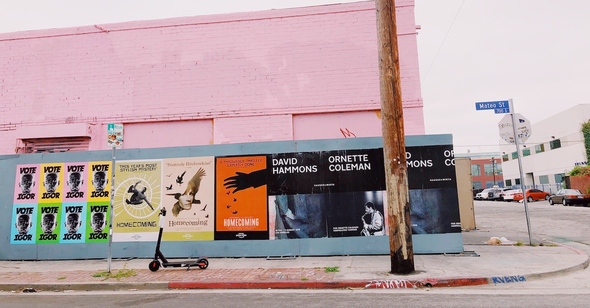 A wall in Los Angeles features many advertising posters on the exterior.