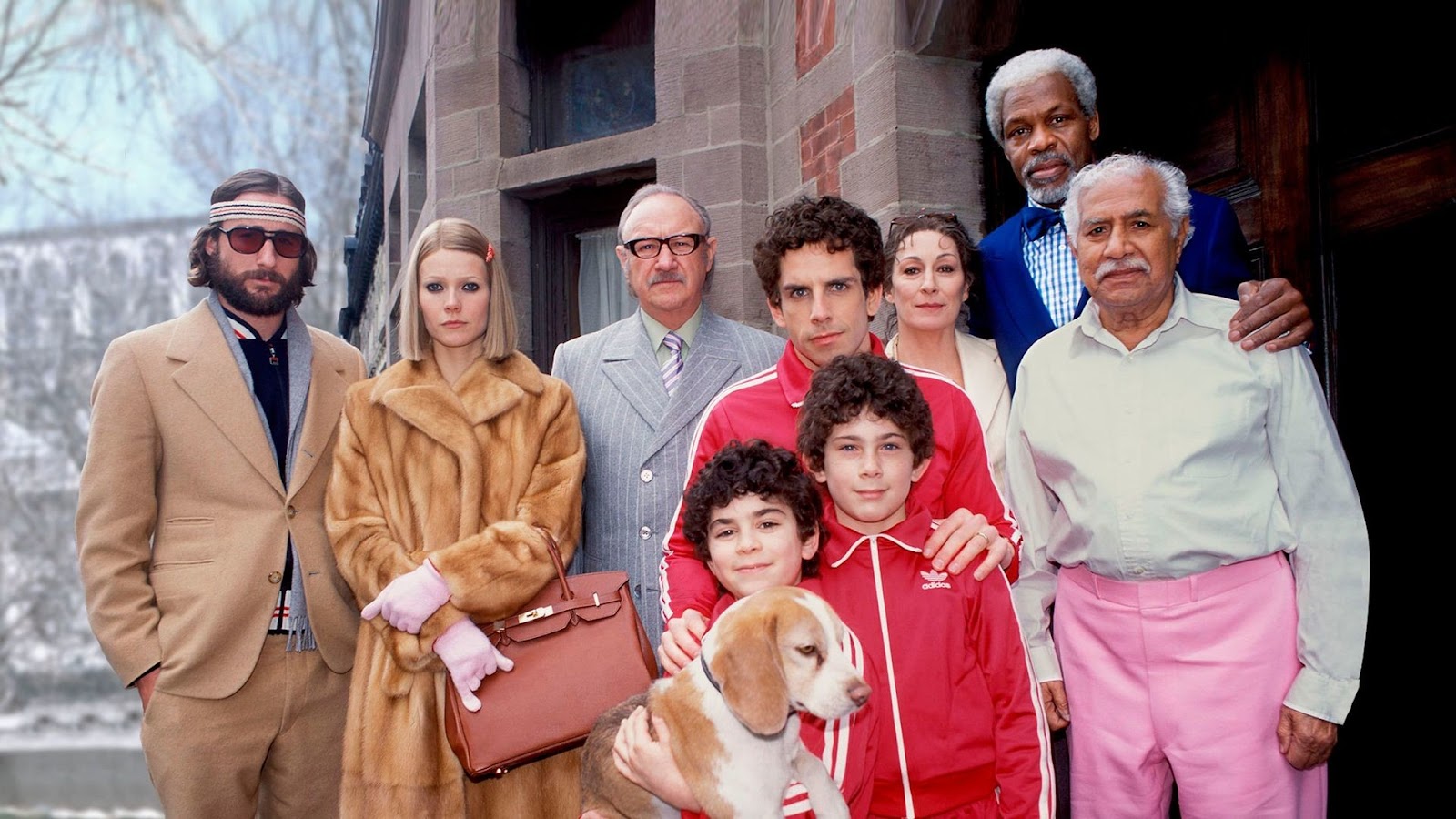 A still from Wes Anderson's 'The Royal Tenenbaums' (2001), the colorful cast in huddled for a group photo.