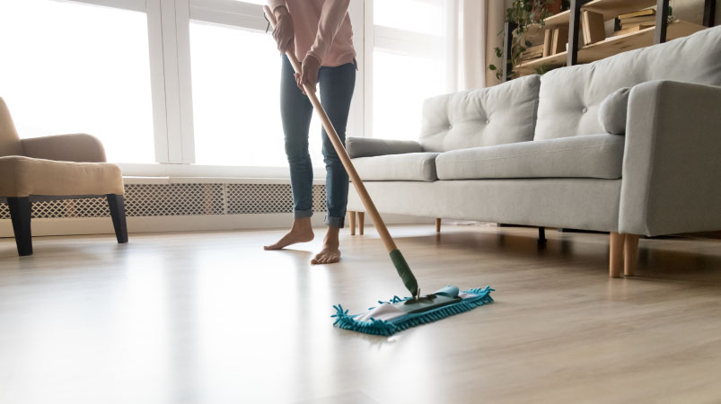 A woman dry mopping her hardwood floors