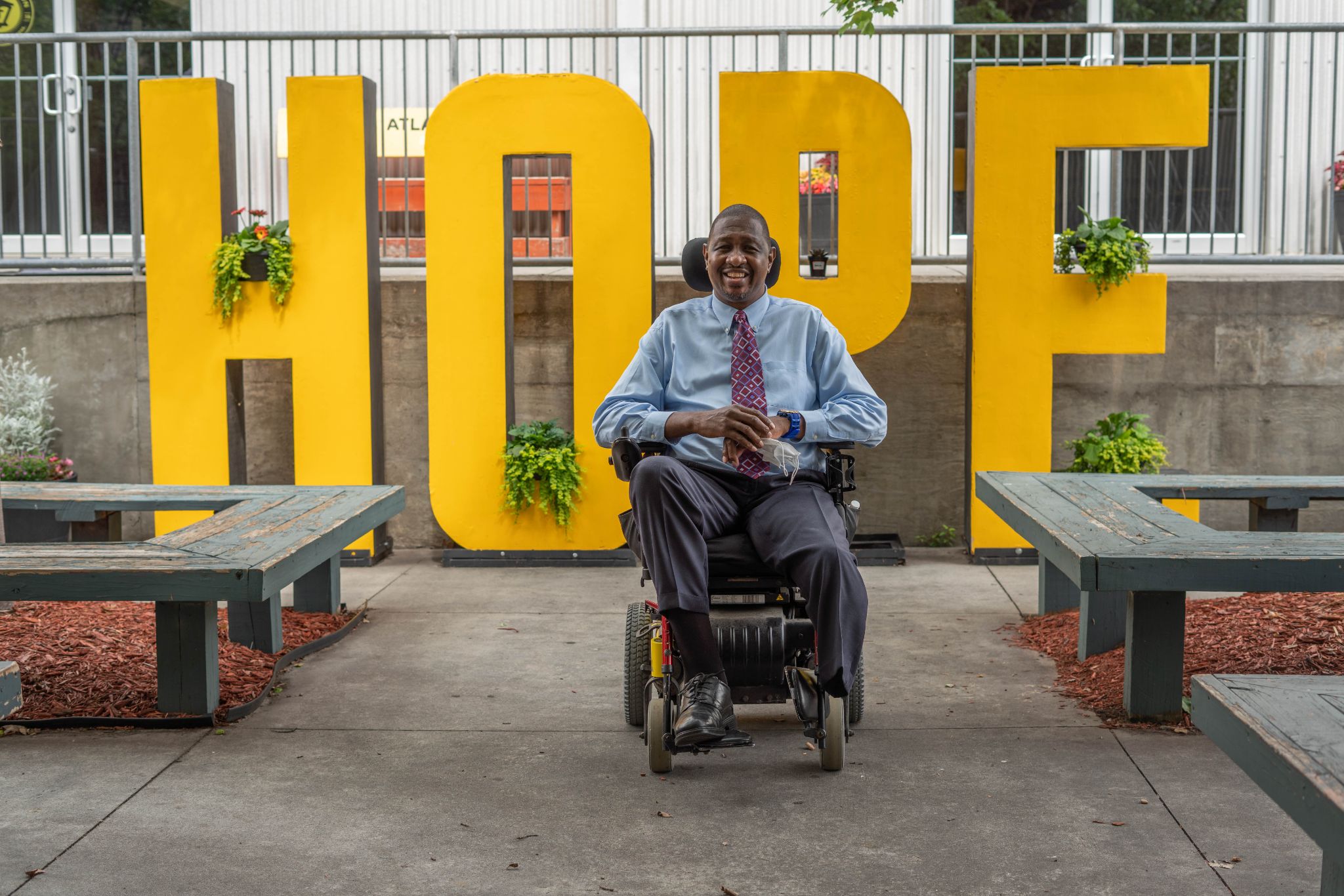 Eric in his wheelchair sitting in front of the HOPE sign at Atlanta Mission