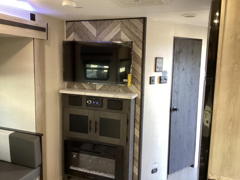 The entertainment unit in this RV features a TV, plenty of storage, and a fireplace.