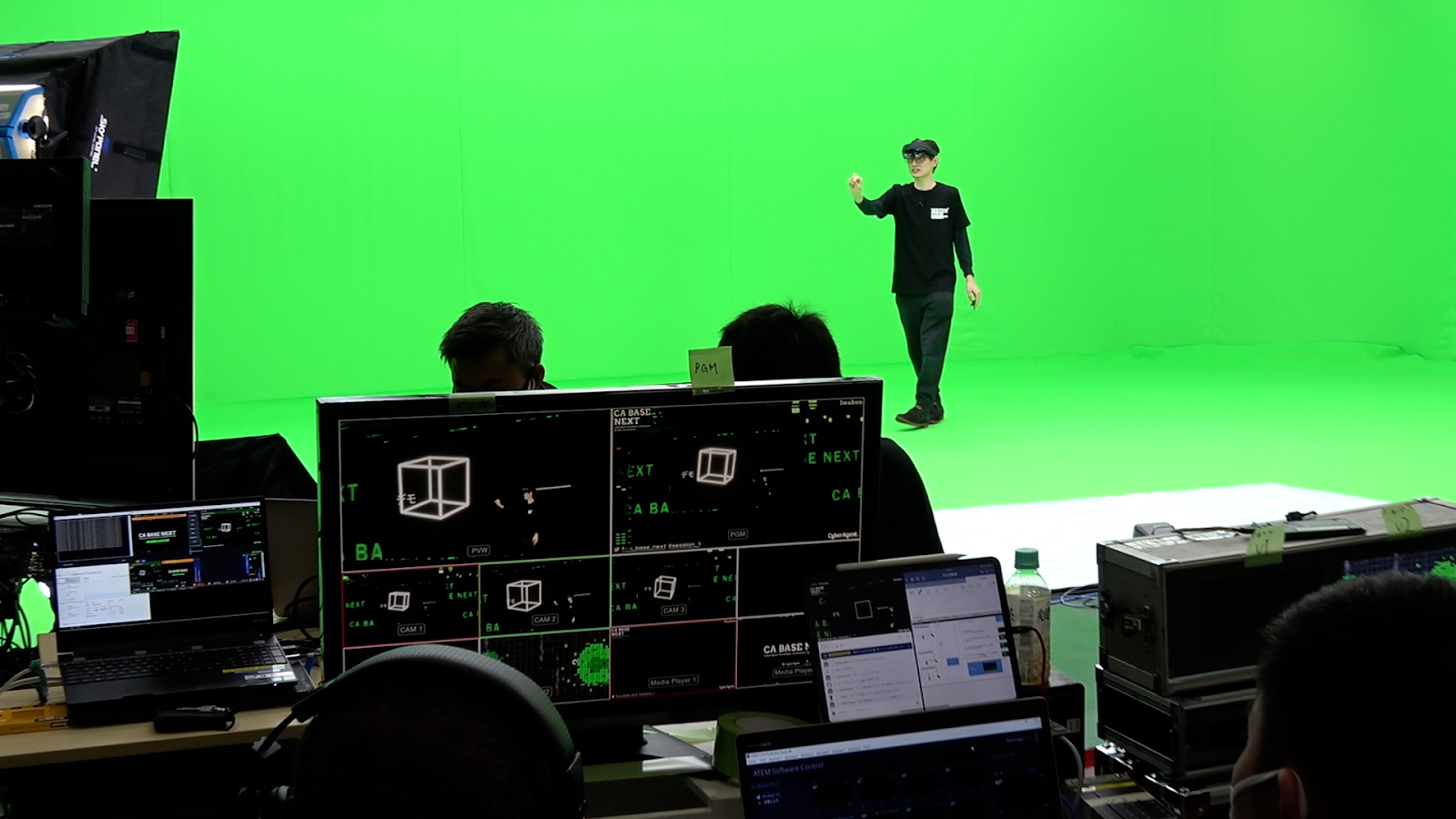 写真: グリーンバックのスタジオではHoloLensを被った人間を撮影し、合成後ではバーチャルな空間にいるように見えます