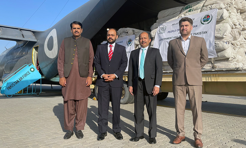 A group of men standing in front of a plane

Description automatically generated with medium confidence