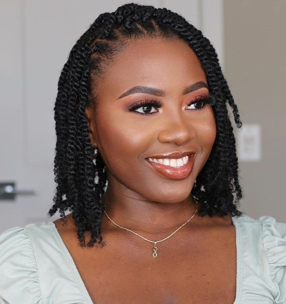 a lady smiling and showing off her two-strand twists hairstyle