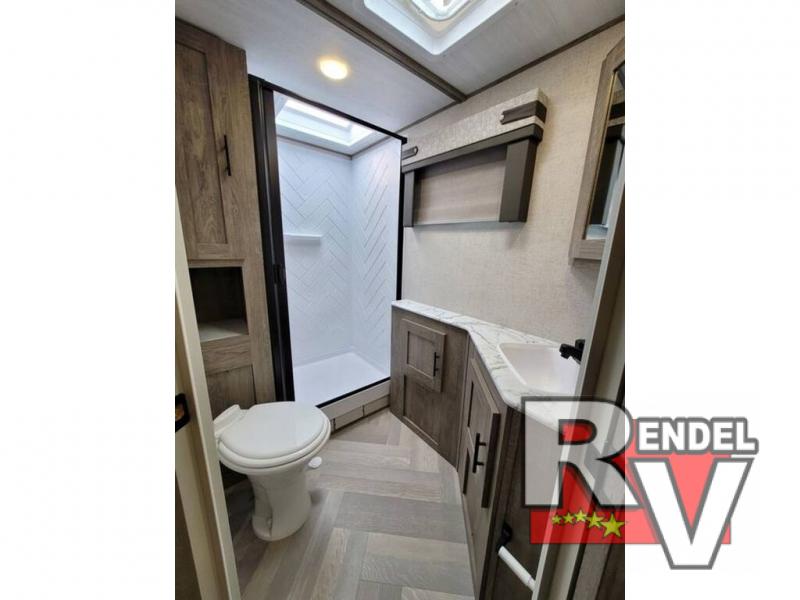 The beautiful bathroom features a walk-in shower with a skylight overhead.