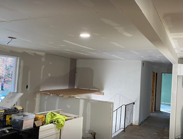 An unfinished kitchen with white walls prepped for drywall installation.